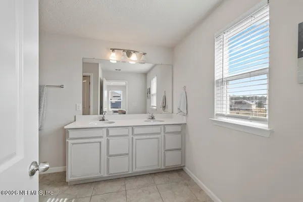 a bathroom with a double vanity sink mirror and shower