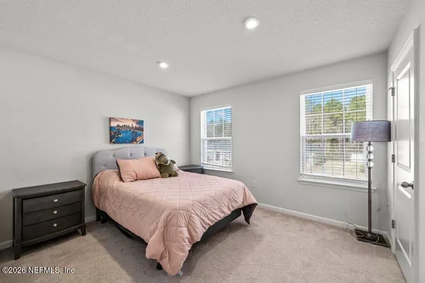 a bedroom with a bed a lamp and a window
