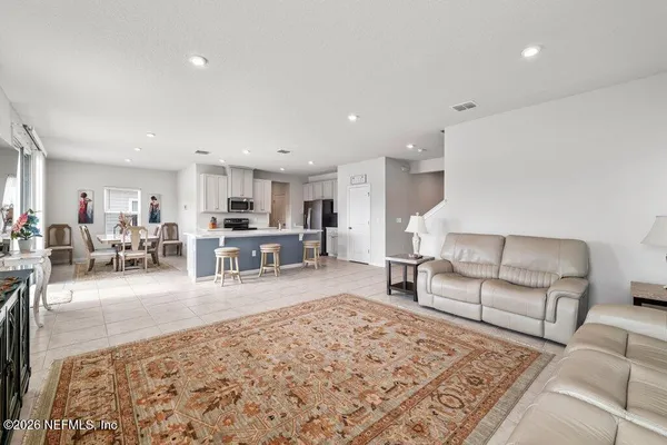 a living room with furniture and a dining table with kitchen view