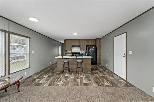 a living room with a couch and a dining table with kitchen view