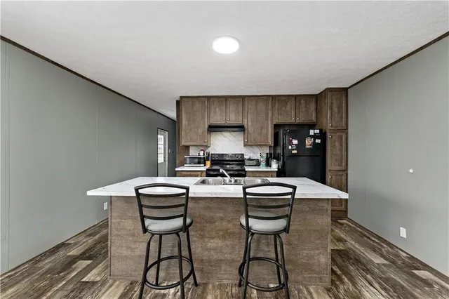 a kitchen with stainless steel appliances a stove a table and chairs in it