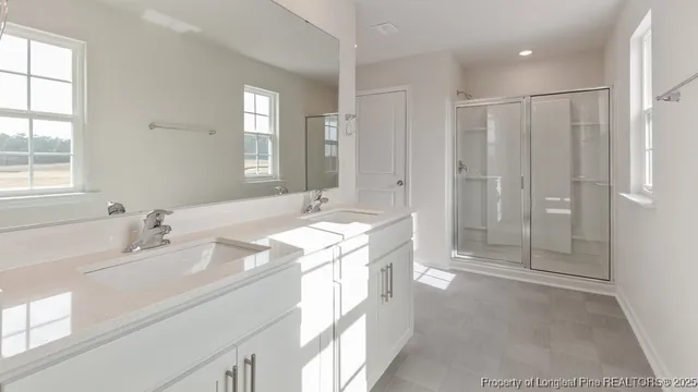 a spacious bathroom with a shower sink and mirror