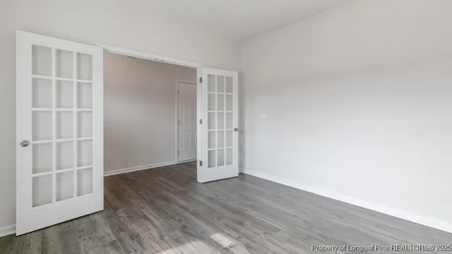an empty room with wooden floor & closet and windows