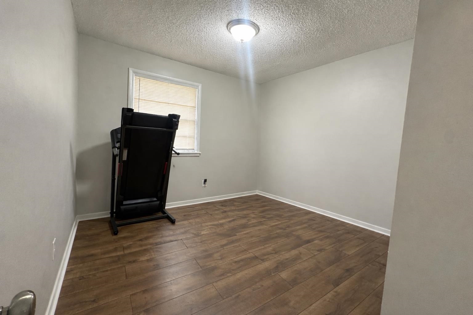 3534 Rochester Road Memphis, TN 38109 - Photo 8 of 13 Workout area featuring dark wood-type flooring and a textured ceiling