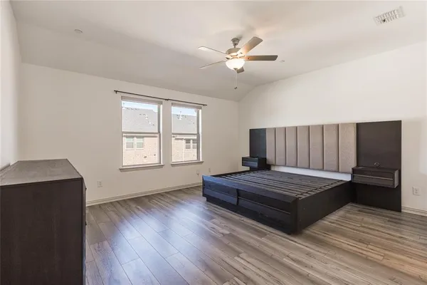 a bedroom with a bed and wooden floor