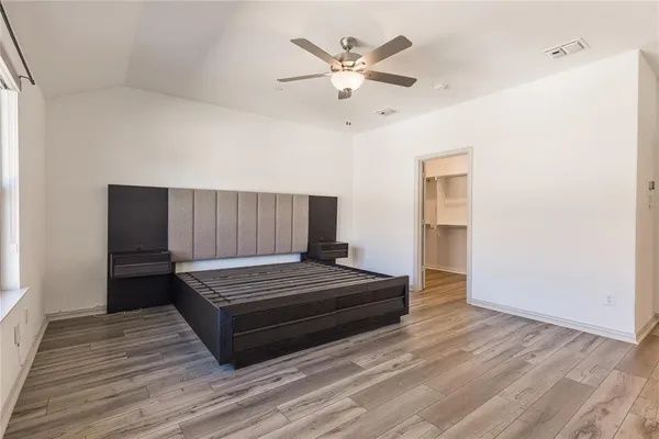 a bedroom with a bed and a ceiling fan