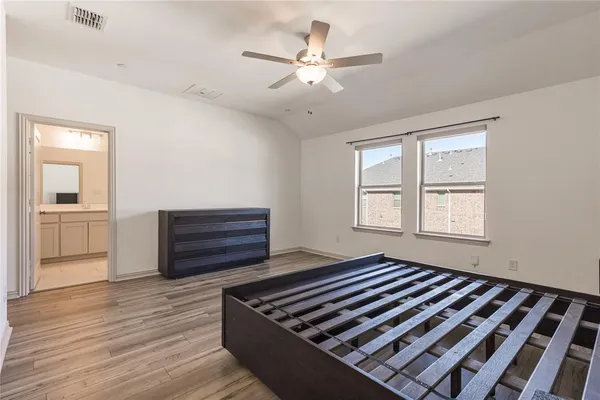 a bedroom with wooden floor and a window