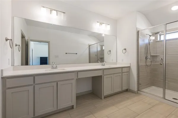 a bathroom with a double vanity sink mirror and shower