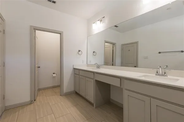 a spacious bathroom with a granite countertop sink and a mirror