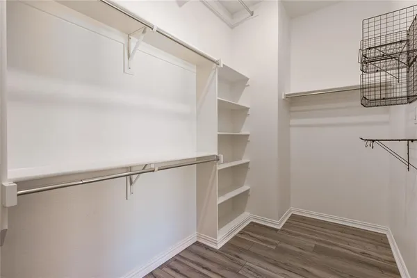 a view of walk in closet with empty racks