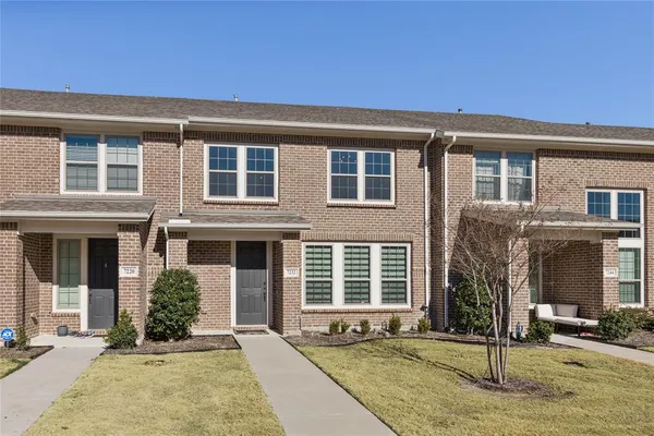 front view of a brick house with a yard