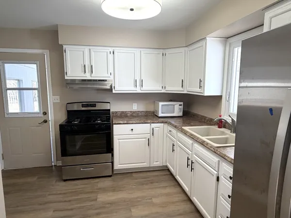 a kitchen with stainless steel appliances granite countertop a refrigerator and a stove top oven