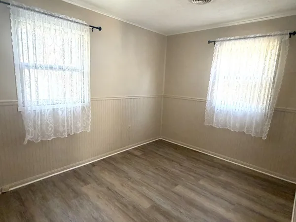 a view of a room with wooden floor and windows