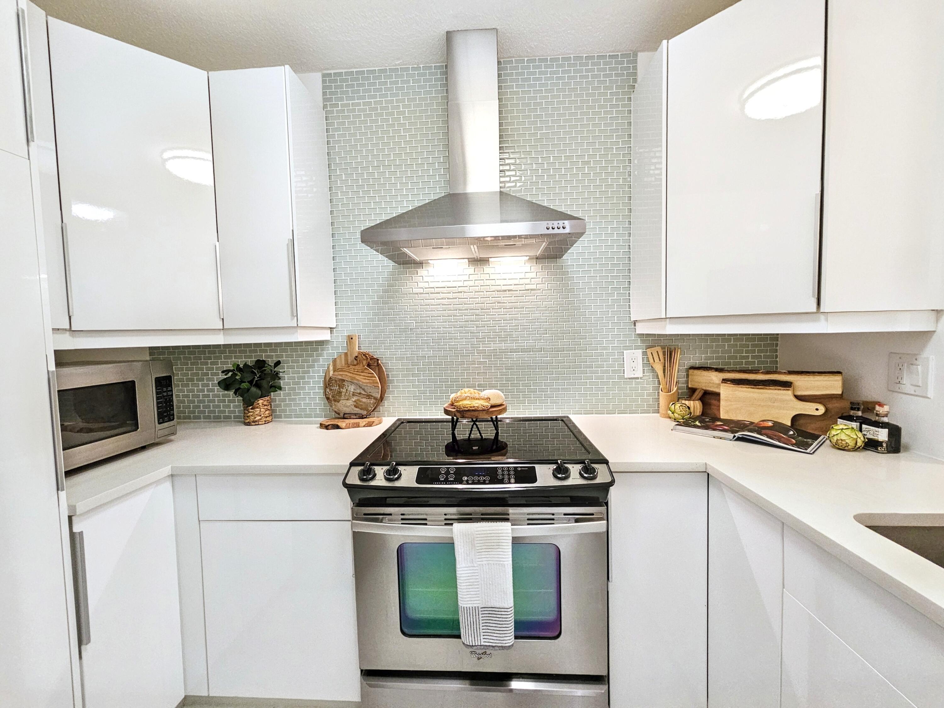 6530 North Ocean Boulevard, Unit 1080 Ocean Ridge, FL 33435 - Photo 3 of 54 a kitchen with a stove a microwave and cabinets