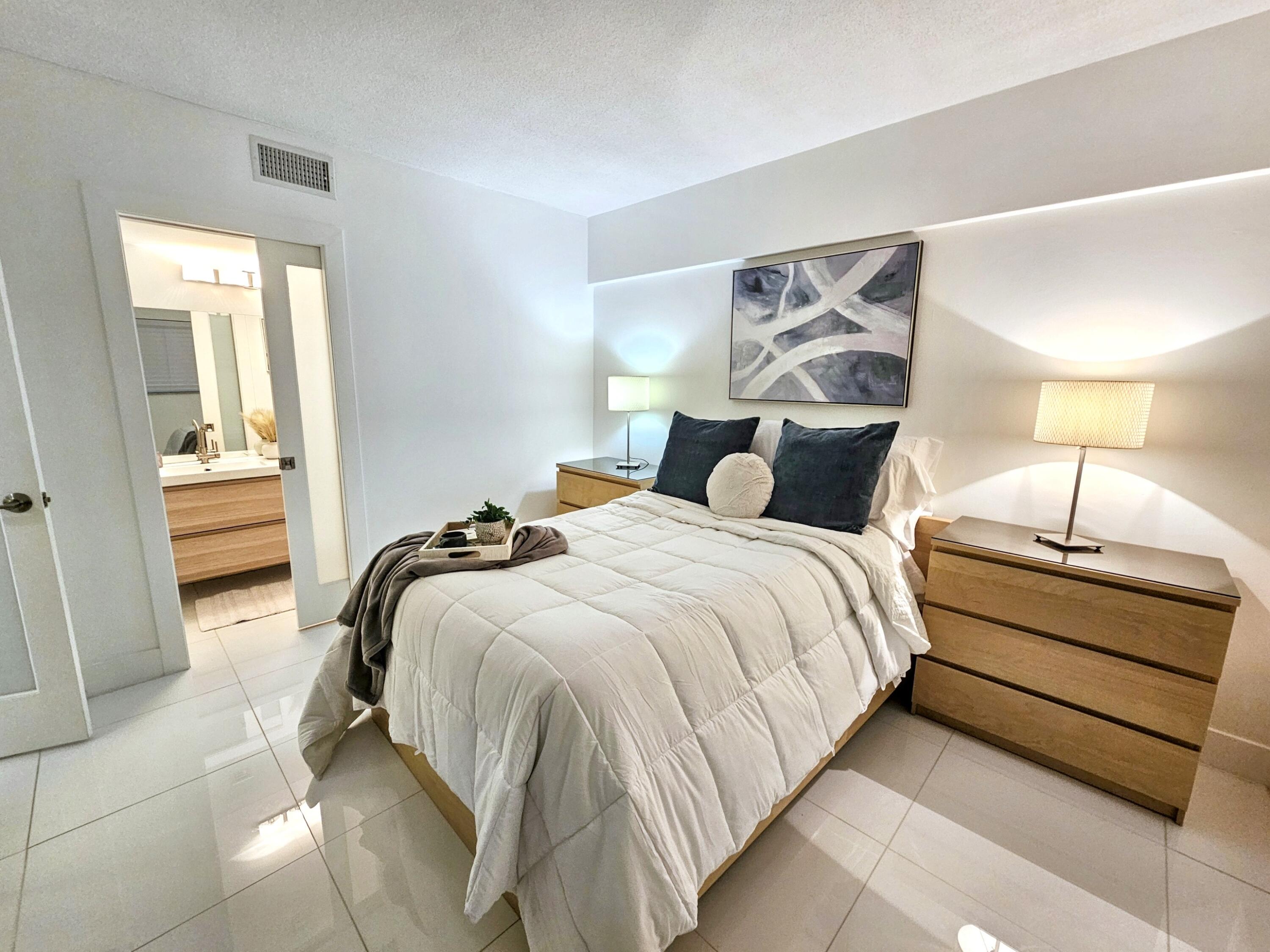 6530 North Ocean Boulevard, Unit 1080 Ocean Ridge, FL 33435 - Photo 33 of 54 a bedroom with a bed and a lamp