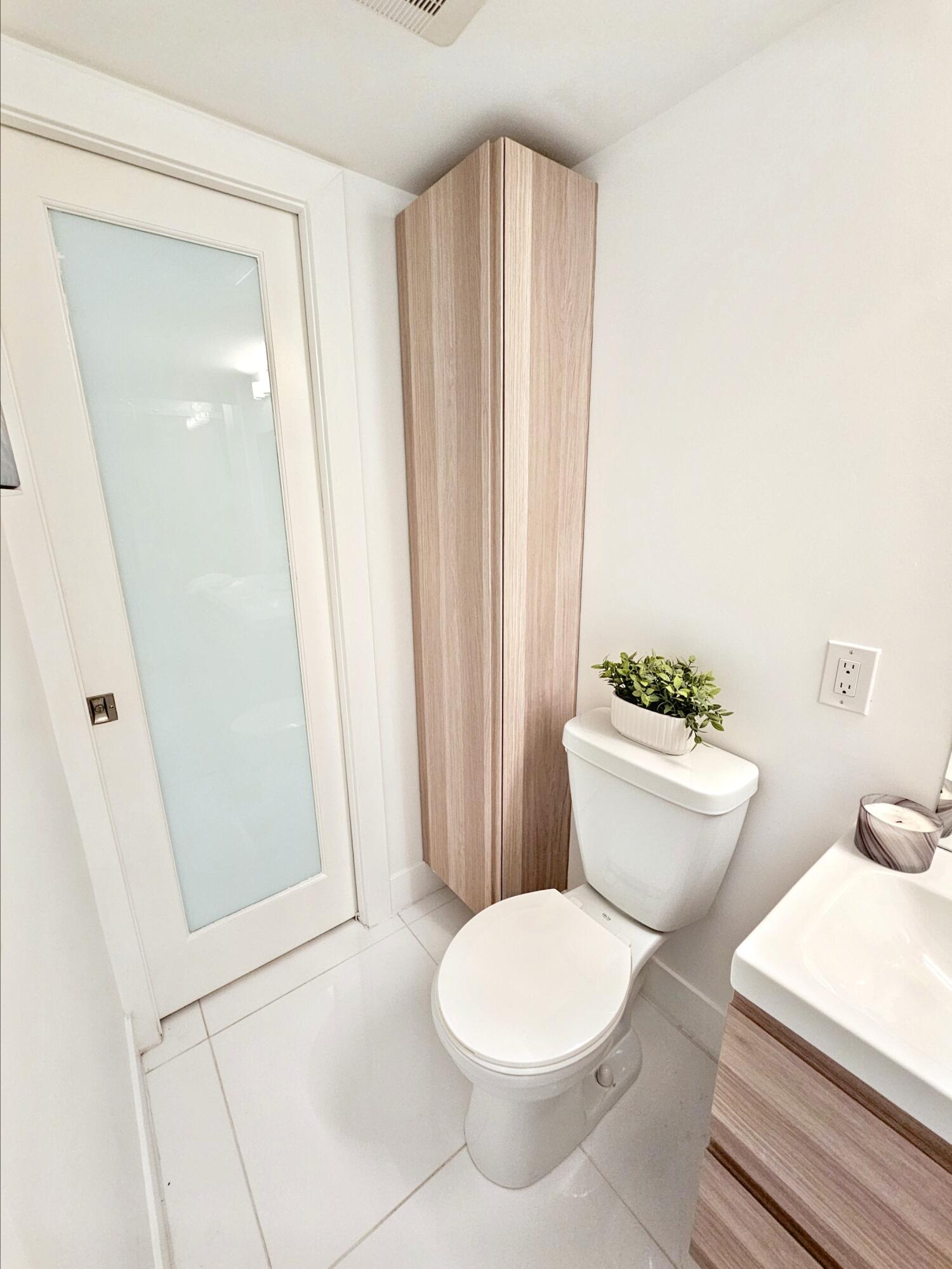 6530 North Ocean Boulevard, Unit 1080 Ocean Ridge, FL 33435 - Photo 38 of 54 a white toilet sitting next to a bathroom sink and vanity