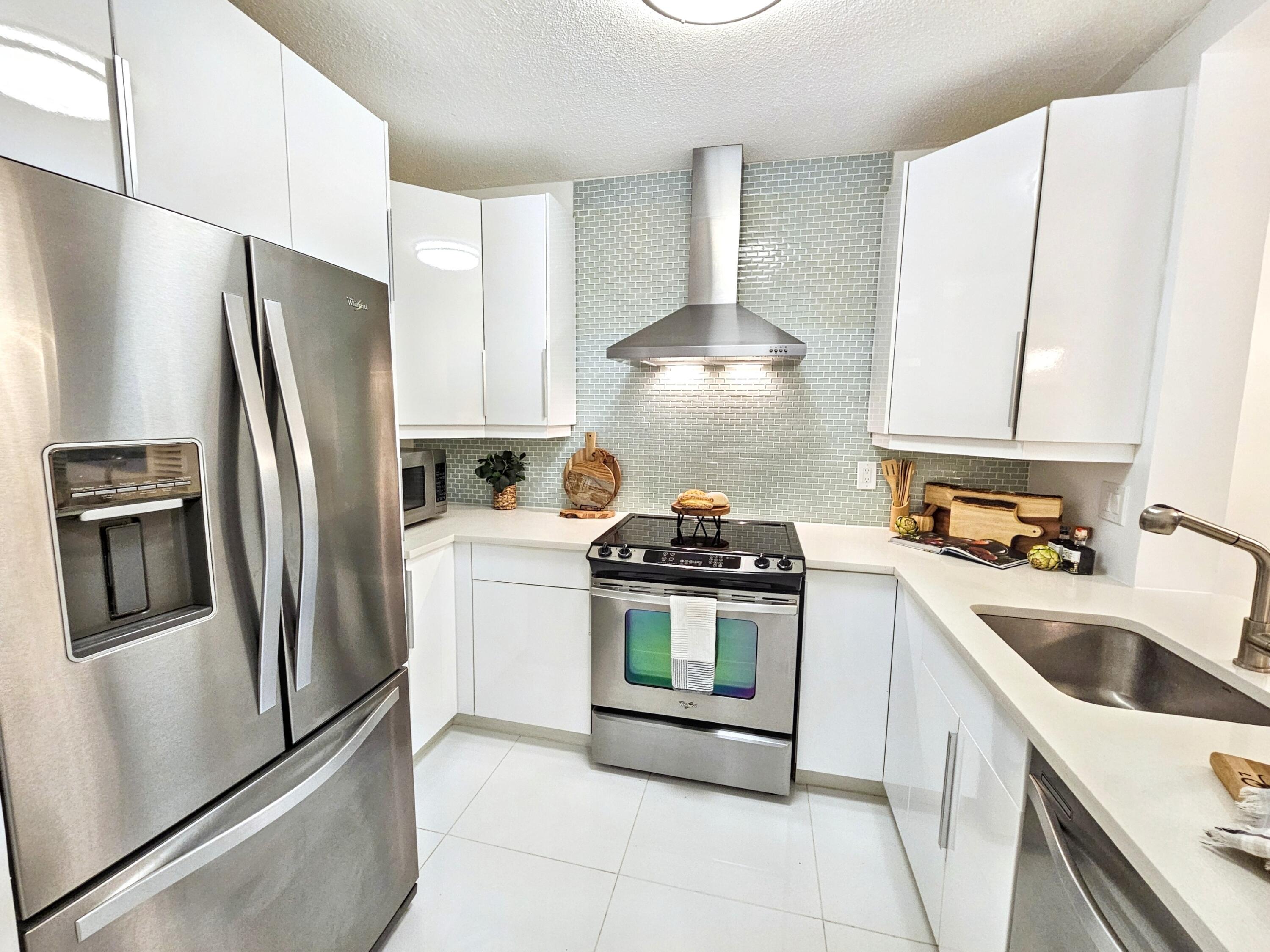 6530 North Ocean Boulevard, Unit 1080 Ocean Ridge, FL 33435 - Photo 4 of 54 a kitchen with stainless steel appliances a refrigerator a stove a sink and a refrigerator