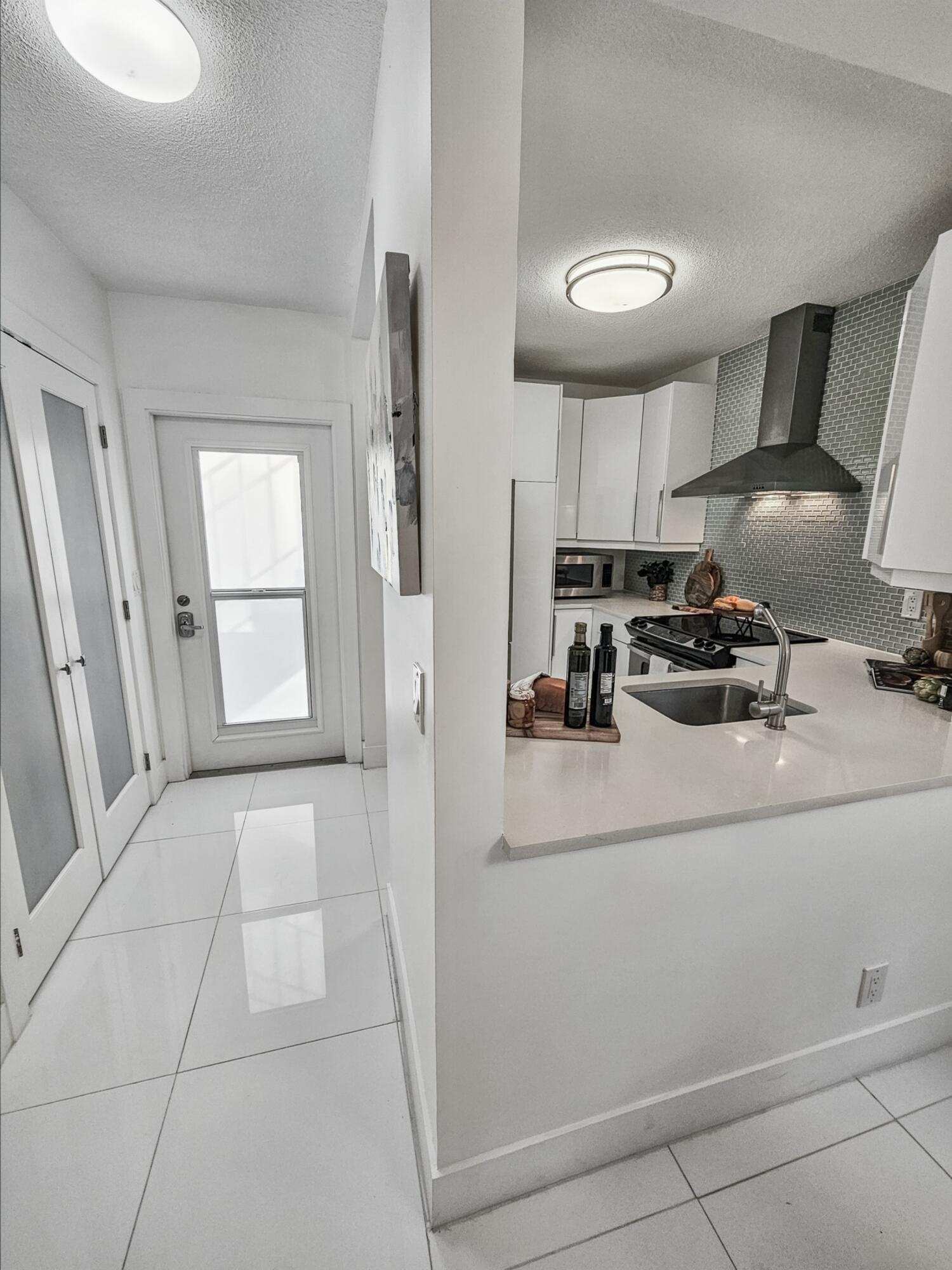 6530 North Ocean Boulevard, Unit 1080 Ocean Ridge, FL 33435 - Photo 7 of 54 a kitchen with a refrigerator and white cabinets