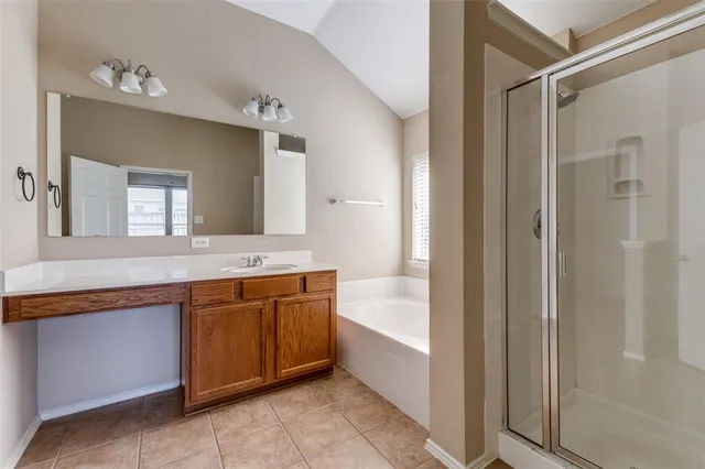 a spacious bathroom with a tub sink and mirror