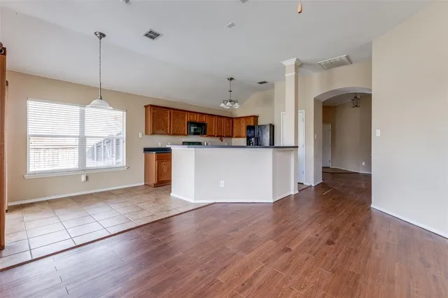a view of a kitchen with wooden floor and a window