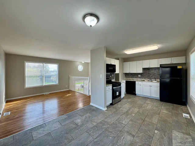 a large kitchen with stainless steel appliances granite countertop a refrigerator and a stove top oven