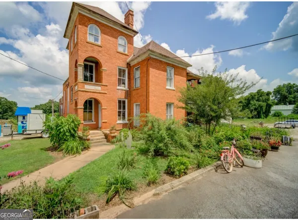a view of a house with a yard and sitting area