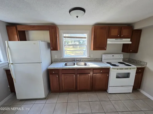 a kitchen with a stove a refrigerator and a sink