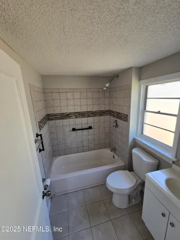 a bathroom with a tub a toilet and a shower