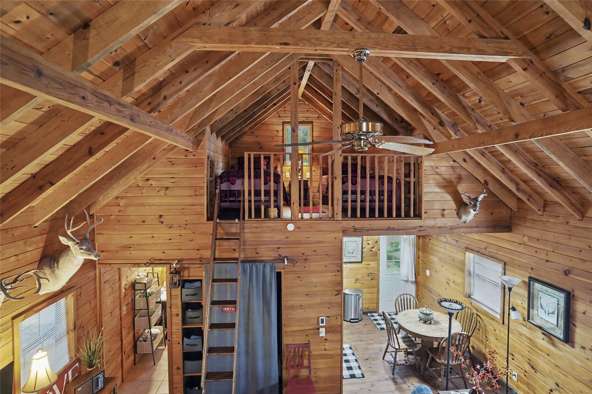 46420 South 590 Road Jay, OK 74346 - Photo 17 of 63 Vaulted wood-finish ceiling with exposed beams, wood-finish walls, lofted area with wood railing, and a ceiling fan