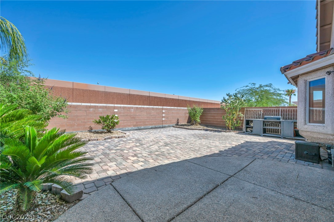 6405 North Raptor Court North Las Vegas, NV 89084 - Photo 46 of 66 A private backyard oasis features durable paver and concrete patios, ideal for outdoor gatherings.