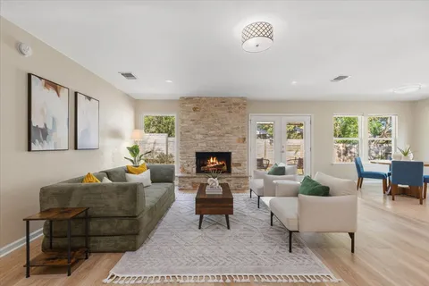a living room with furniture a rug a lamp and a fireplace