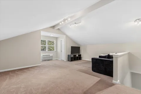a view of a livingroom with a piano and entryway