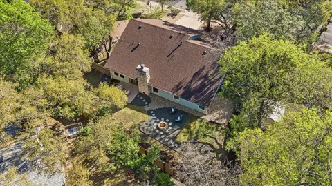 a aerial view of a house with a yard and large trees