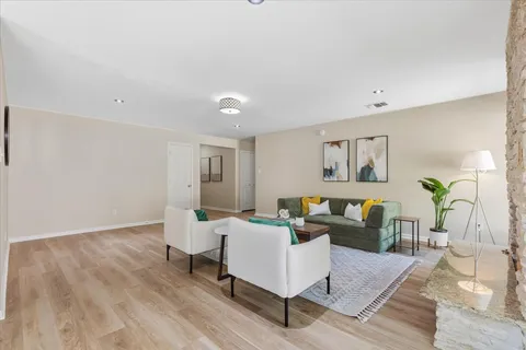 a living room with furniture and wooden floor