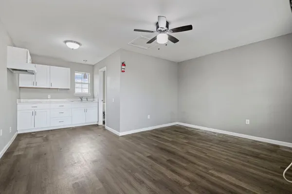 a view of a kitchen with wooden floor and stainless steel appliances