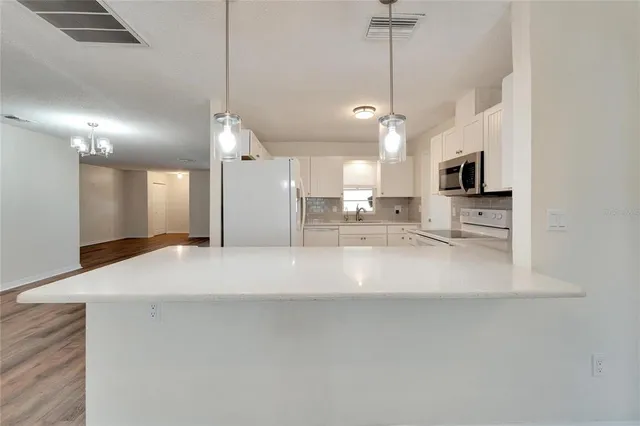 a kitchen with white cabinets appliances and a sink