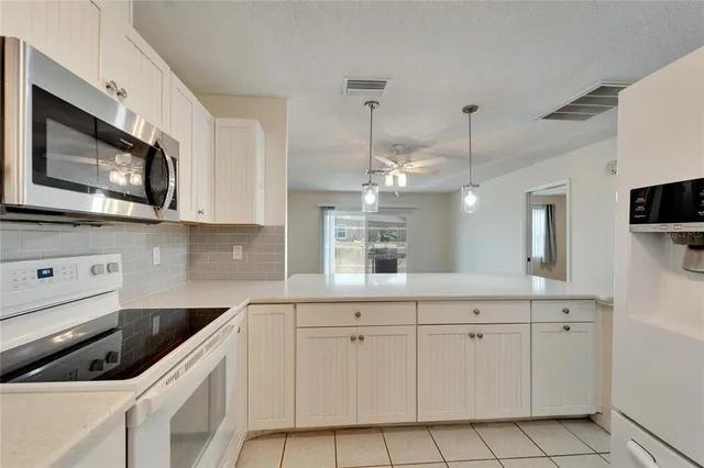 a kitchen with appliances a sink and cabinets