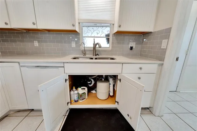 a kitchen with white cabinets and appliances