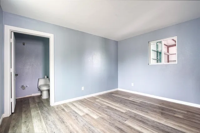 a view of a room with a stylish ceiling fan and hardwood floor