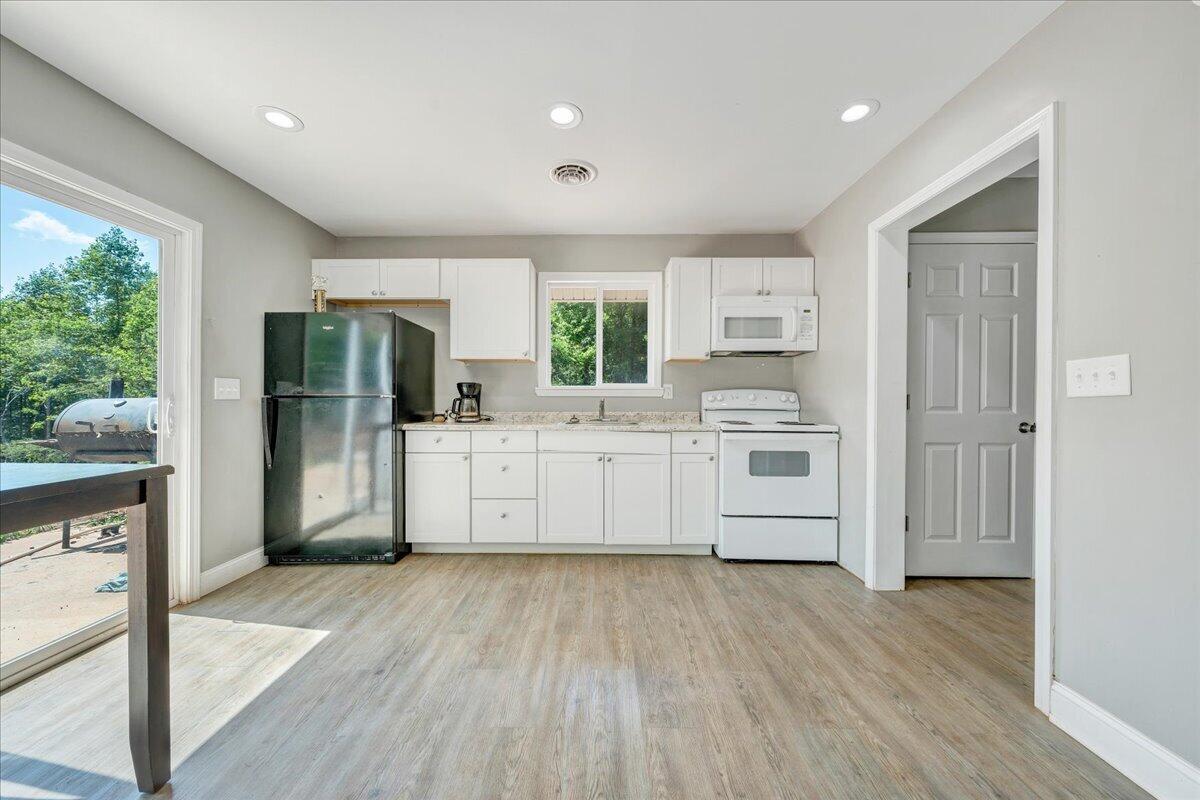 6379 Fork Mountain Road Rocky Mount, VA 24151 - Photo 4 of 9 a kitchen with stainless steel appliances a white cabinets and a wooden floor