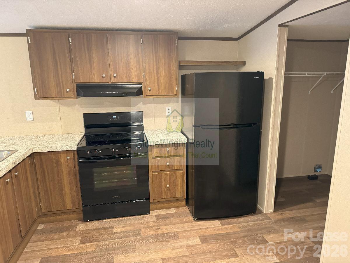 2034 Shelby Road, Unit 8 Kings Mountain, NC 28086 - Photo 4 of 8 a kitchen with a refrigerator and cabinets