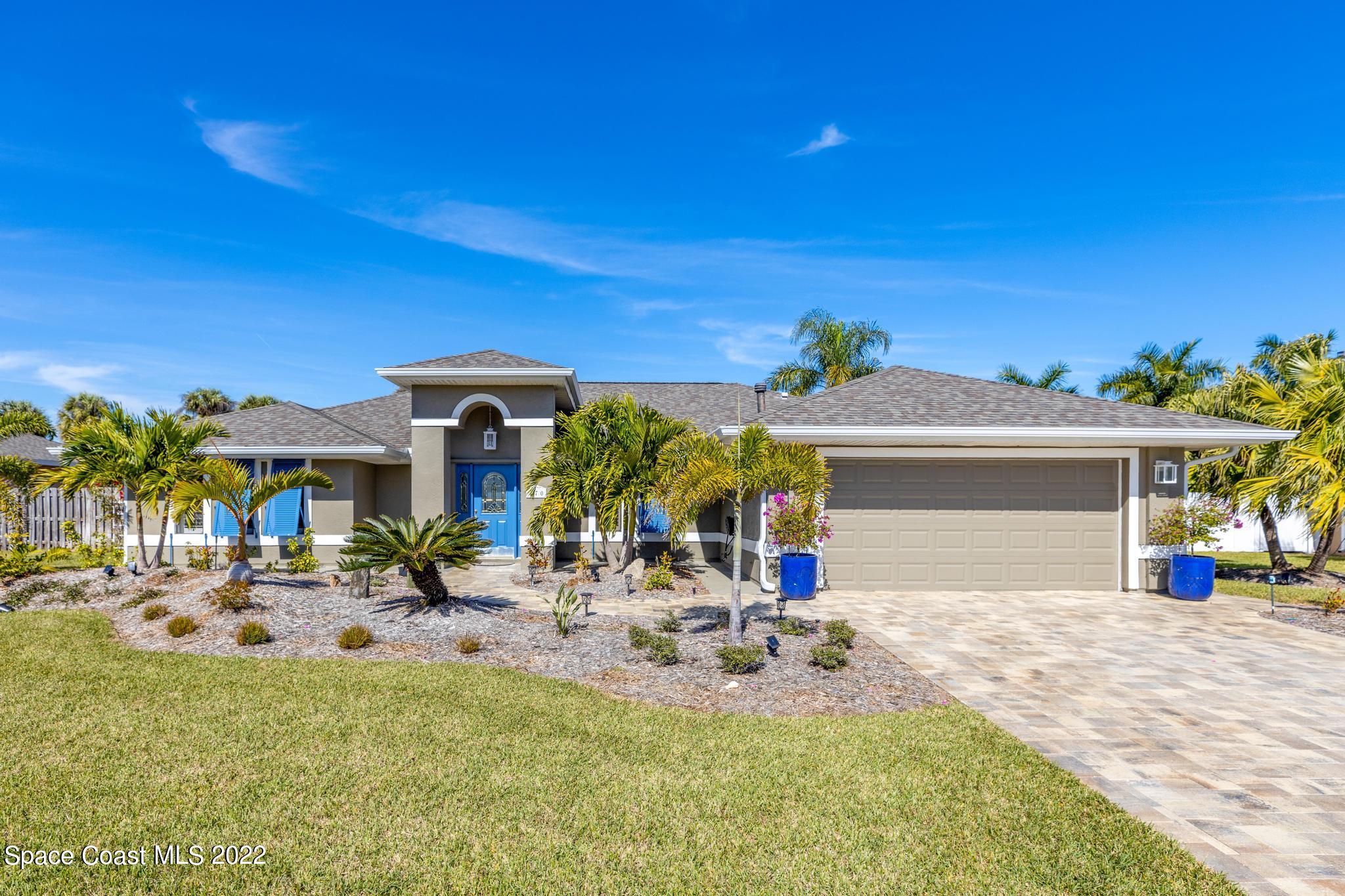 a view of a house with backyard and sitting area