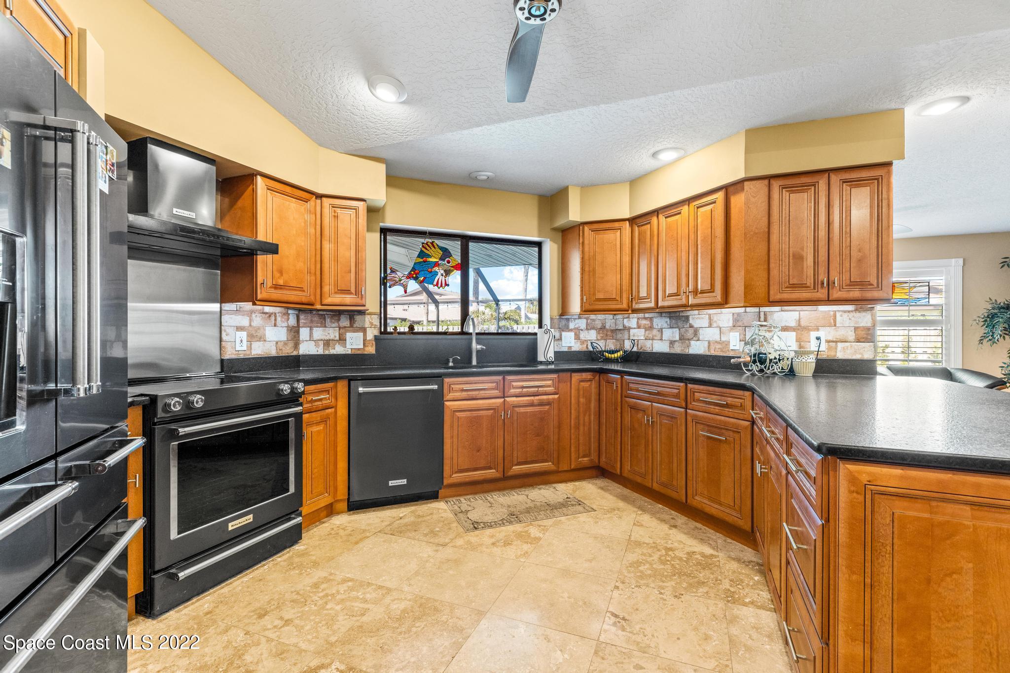 470 Veracruz Boulevard Indialantic, FL 32903 - Photo 4 of 25 a kitchen with stainless steel appliances granite countertop a stove a sink dishwasher and a refrigerator