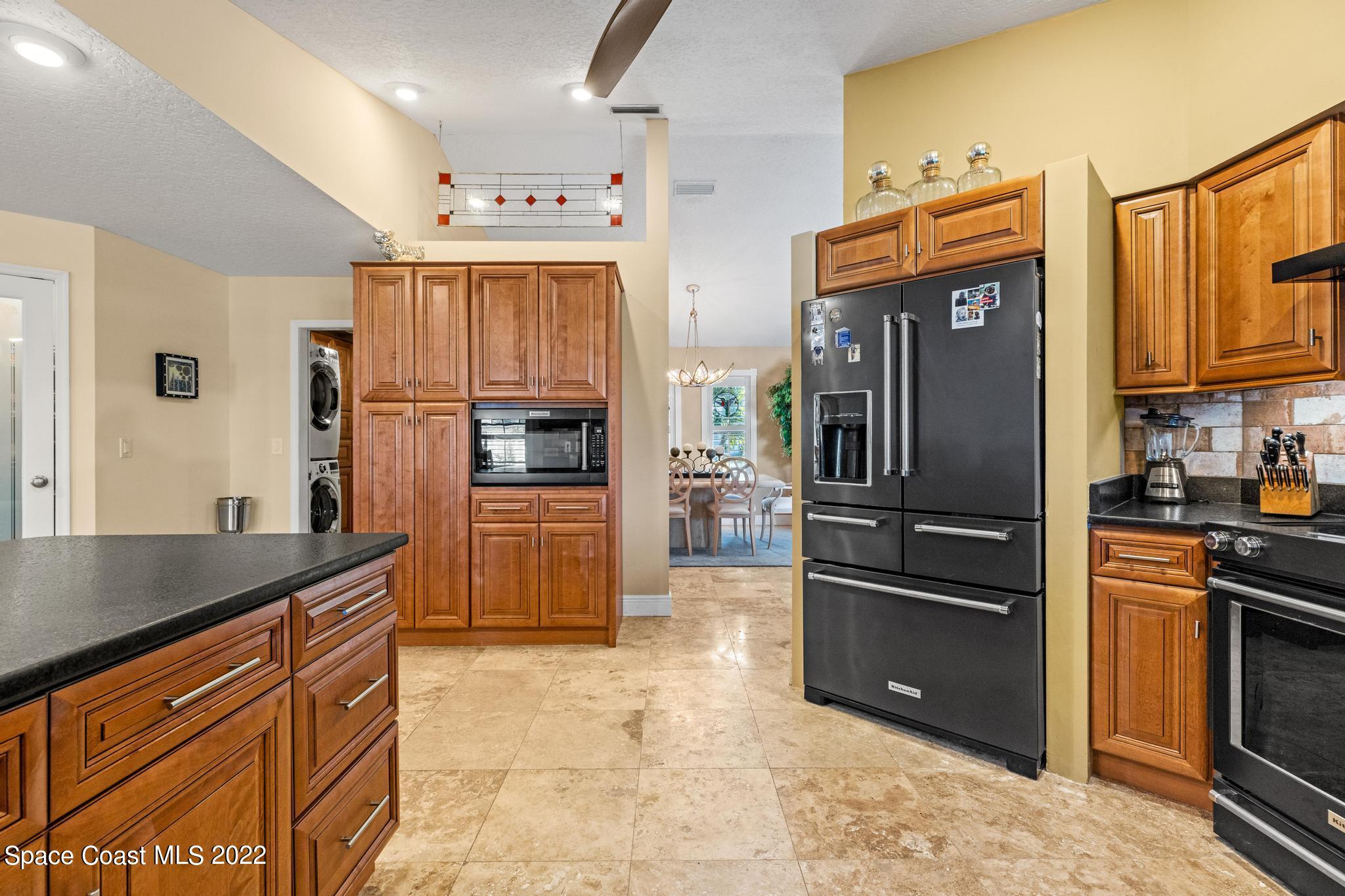 470 Veracruz Boulevard Indialantic, FL 32903 - Photo 5 of 25 a kitchen with granite countertop a refrigerator and a stove top oven