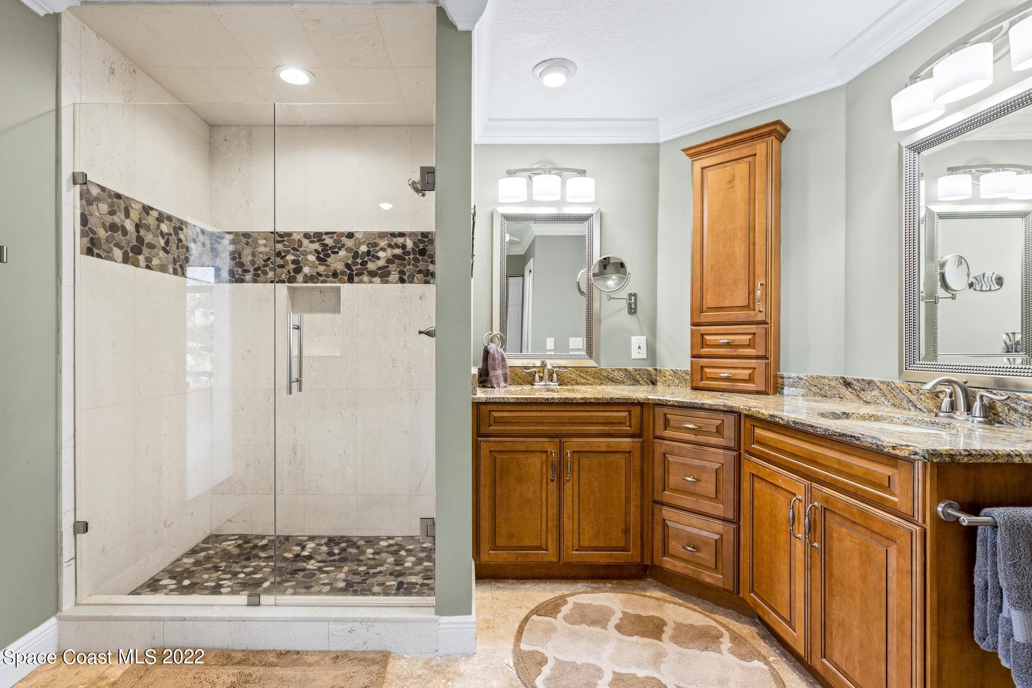 470 Veracruz Boulevard Indialantic, FL 32903 - Photo 9 of 25 a bathroom with a granite countertop sink a mirror a vanity and a shower