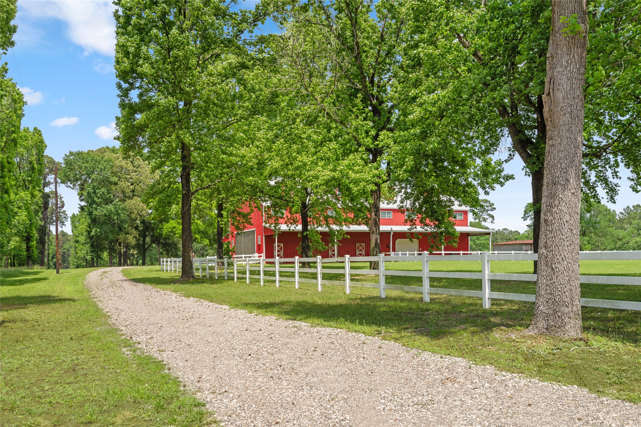 15126 Walden Road Montgomery, TX 77356 - Photo 15 of 50 Charming approach: white picket fence, long drive entering the property, and the barndominium make for classic country character.