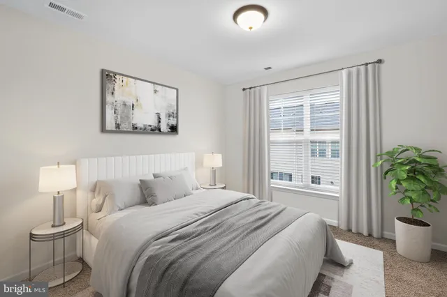 a bedroom with a bed and a potted plant
