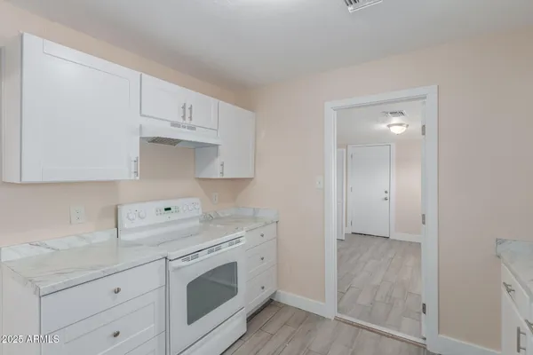 a kitchen with granite countertop white cabinets and white appliances