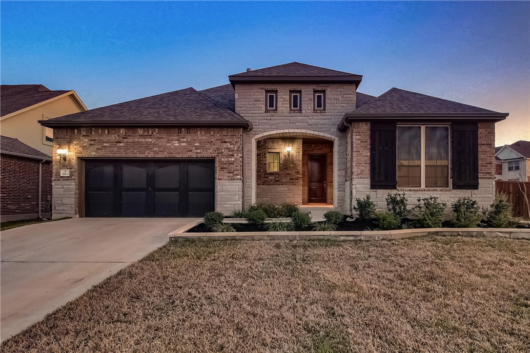 a front view of a house with a yard and garage