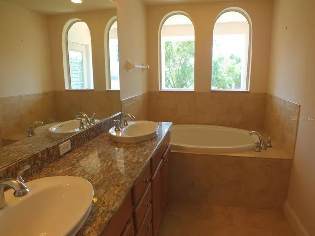 a bathroom with a tub a sink and a window